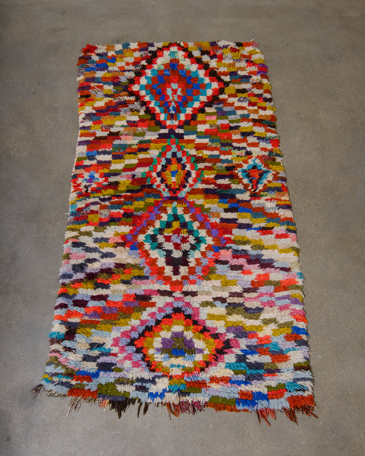 Multicolored geometric patterned rug on a concrete floor